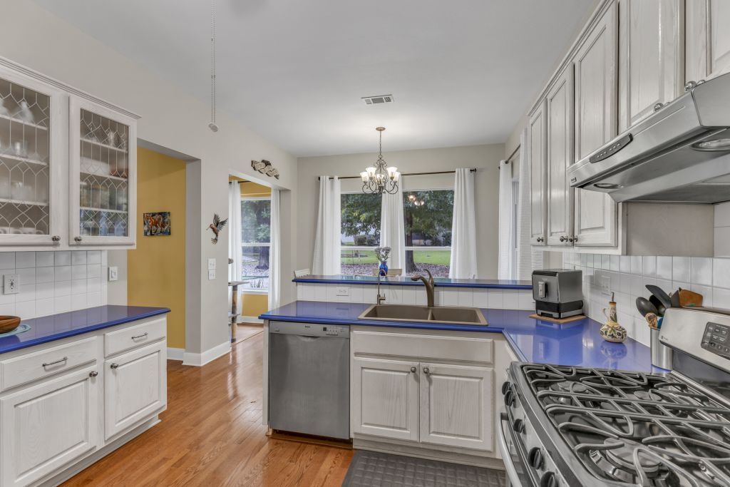 144 Cattle Trail Way Georgetown, TX 78633 - Photo 9 of 37 Bright and airy, this kitchen features vibrant blue counters and a gas range perfect for culinary adventures.