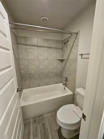 a white toilet sitting next to a bath tub and a shower