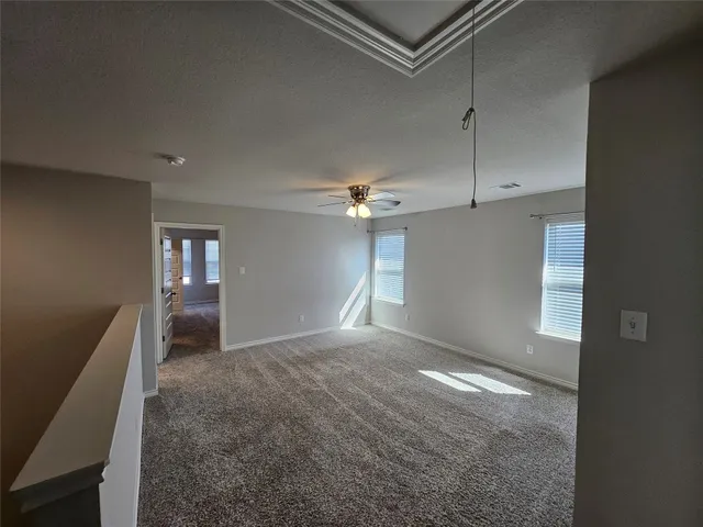 en empty room with windows and ceiling fan