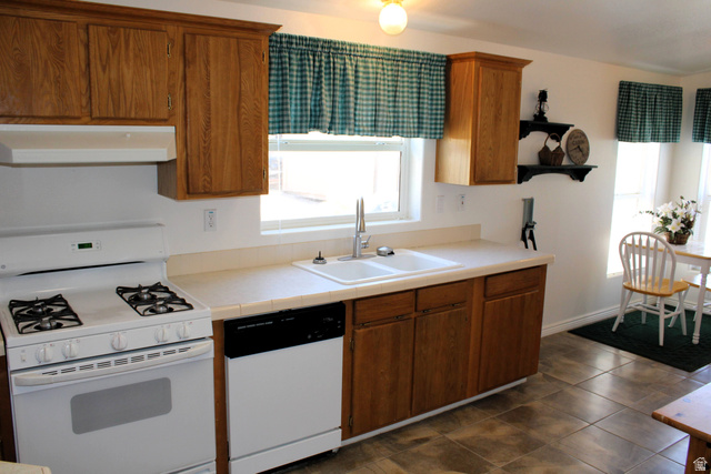 22580 Spring Creek Drive, Unit B61 Fairview, UT 84629 - Photo 11 of 39 Kitchen featuring wood cabinetry, a white gas range with overhead ventilation, a dual-basin sink, and a white dishwasher