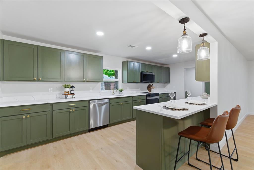 507 Country Club Road Cleburne, TX 76033 - Photo 11 of 39 Well-appointed kitchen featuring extensive green cabinetry with gold hardware, white countertops, stainless steel dishwasher, light wood-finish flooring, and recessed lighting