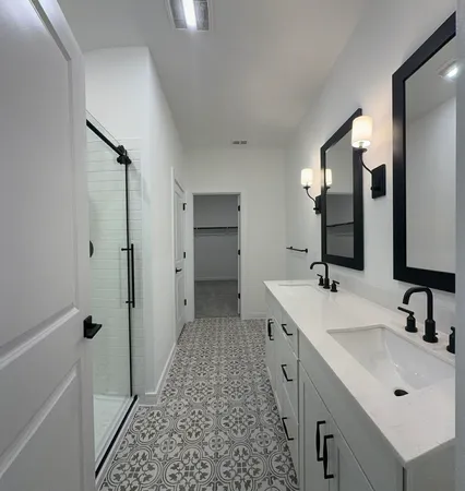 a spacious bathroom with a double vanity sink a mirror and shower