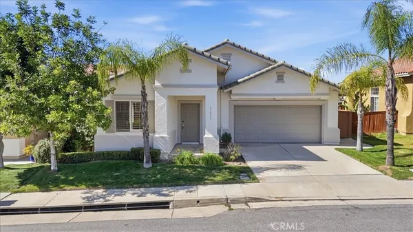 front view of a house with a yard and an trees