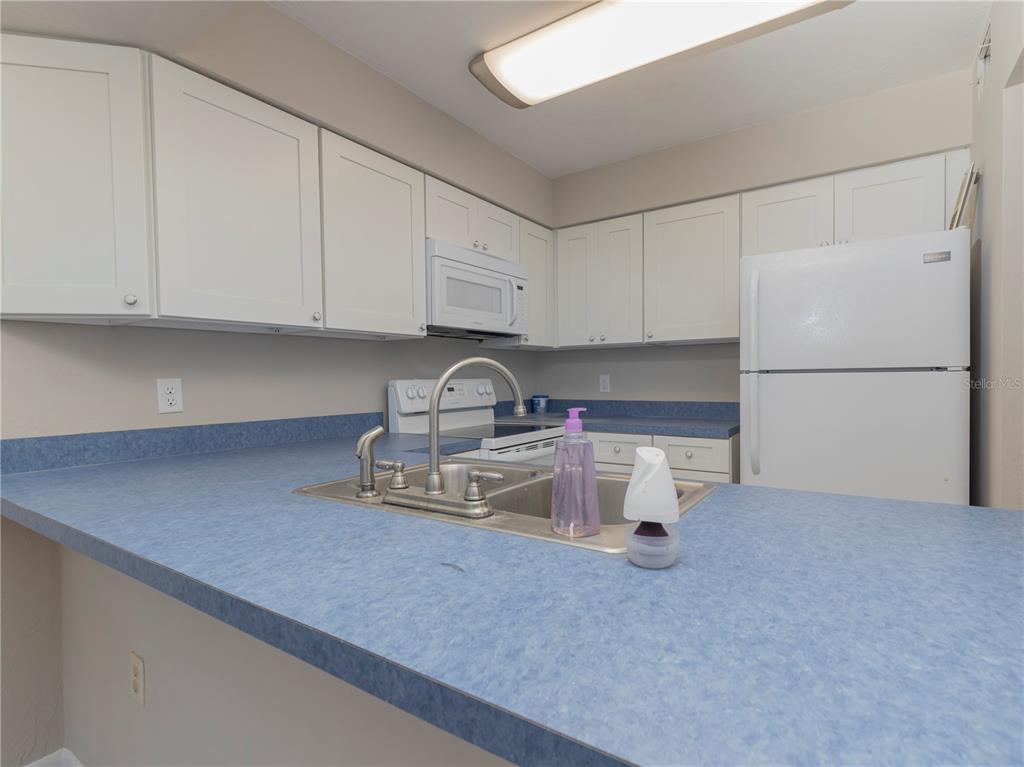 4356 Southwest 20th Lane Gainesville, FL 32607 - Photo 6 of 15 a kitchen with a sink and a refrigerator