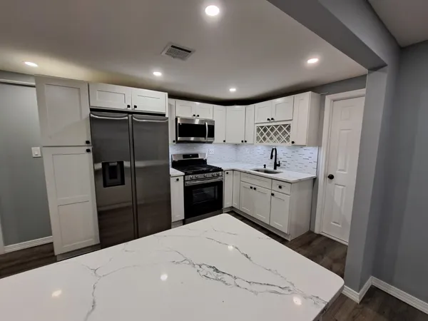 a kitchen with a sink stainless steel appliances and cabinets