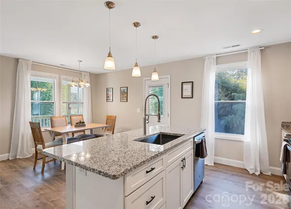 a kitchen with granite countertop a sink and white cabinets
