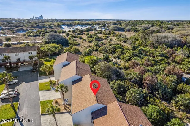 an aerial view of residential houses with outdoor space and parking