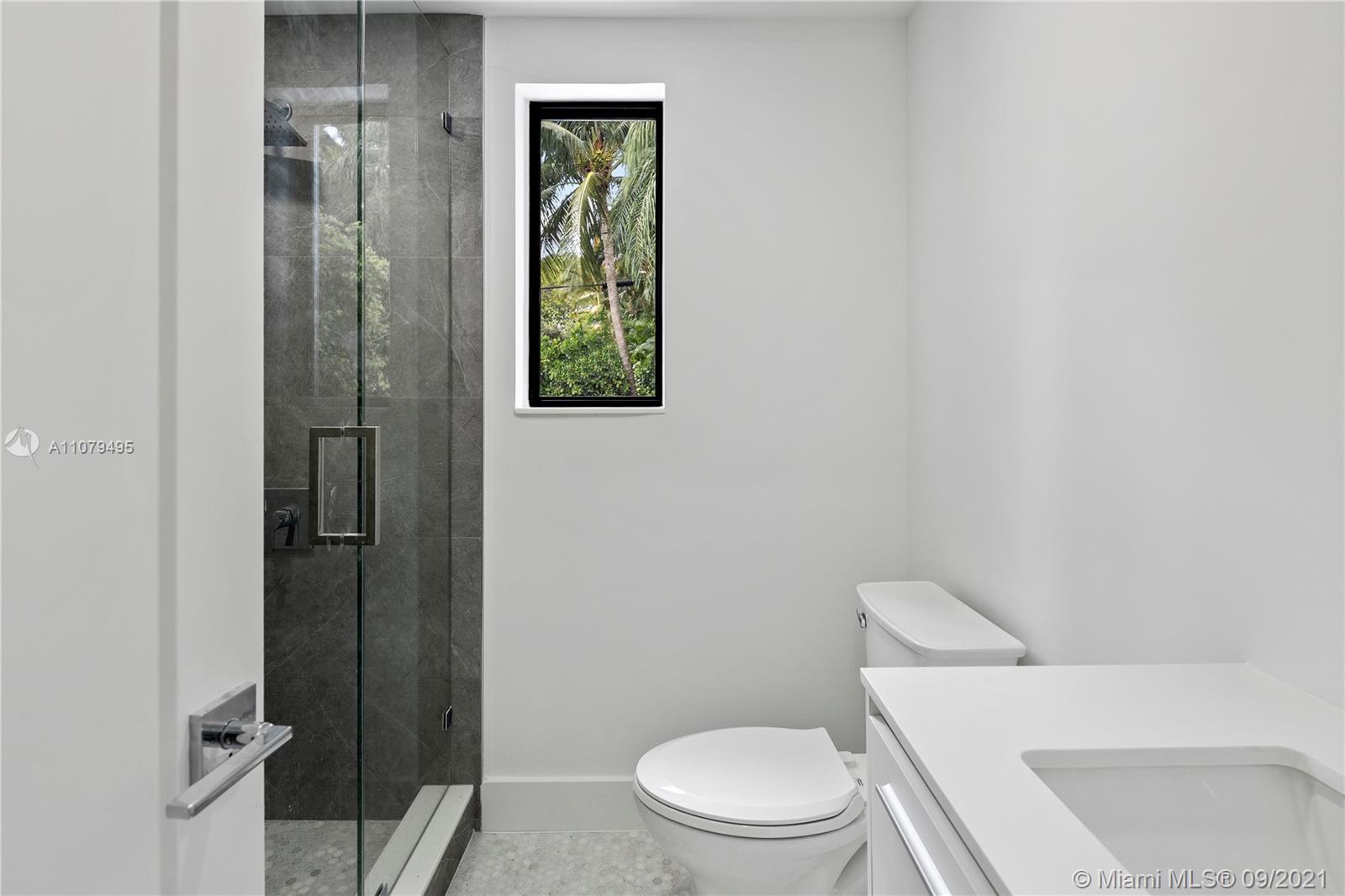 4450 Alton Road Miami Beach, FL 33140 - Photo 20 of 35 a white toilet sitting next to a bathroom sink