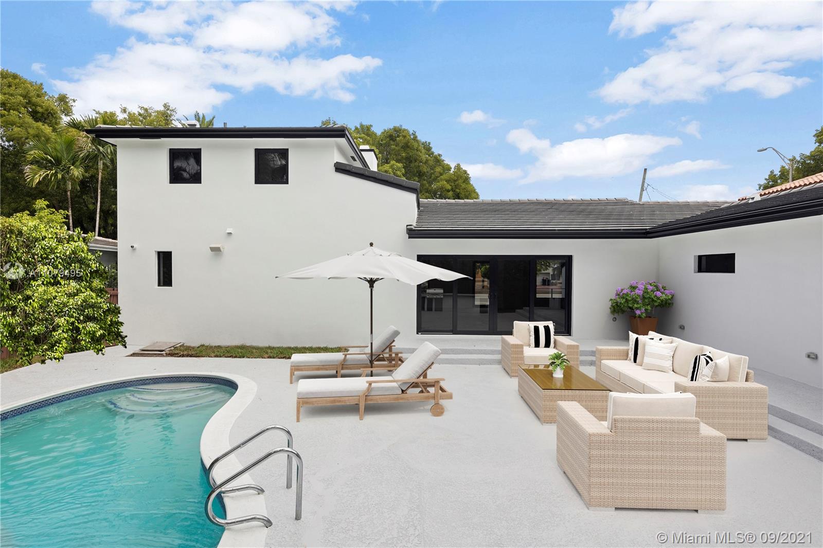 4450 Alton Road Miami Beach, FL 33140 - Photo 32 of 35 a view of a patio with couches table and chairs with wooden floor and fence