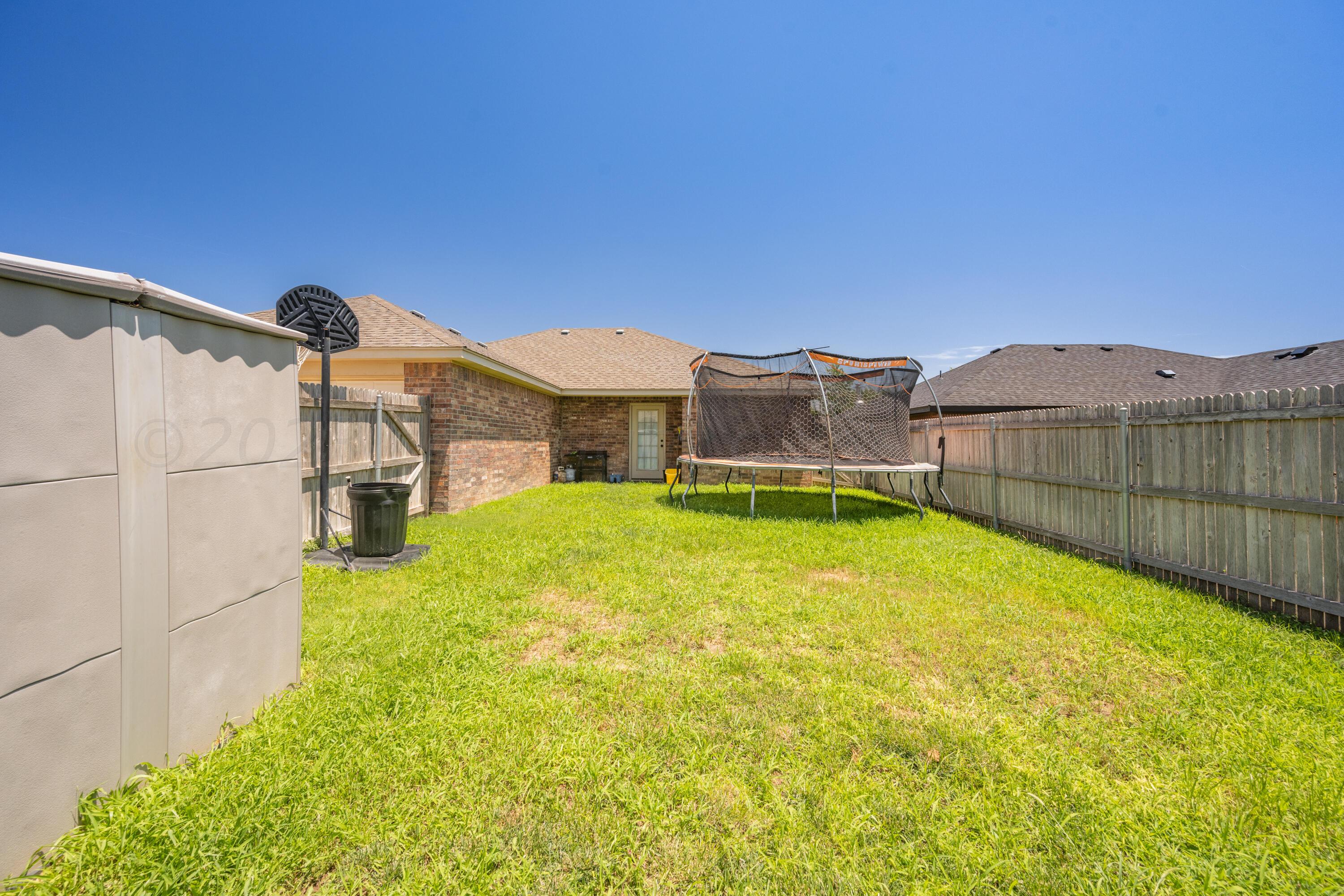 4502 Pine Street Amarillo, TX 79118 - Photo 18 of 20 a view of a large house with a big yard and large tree