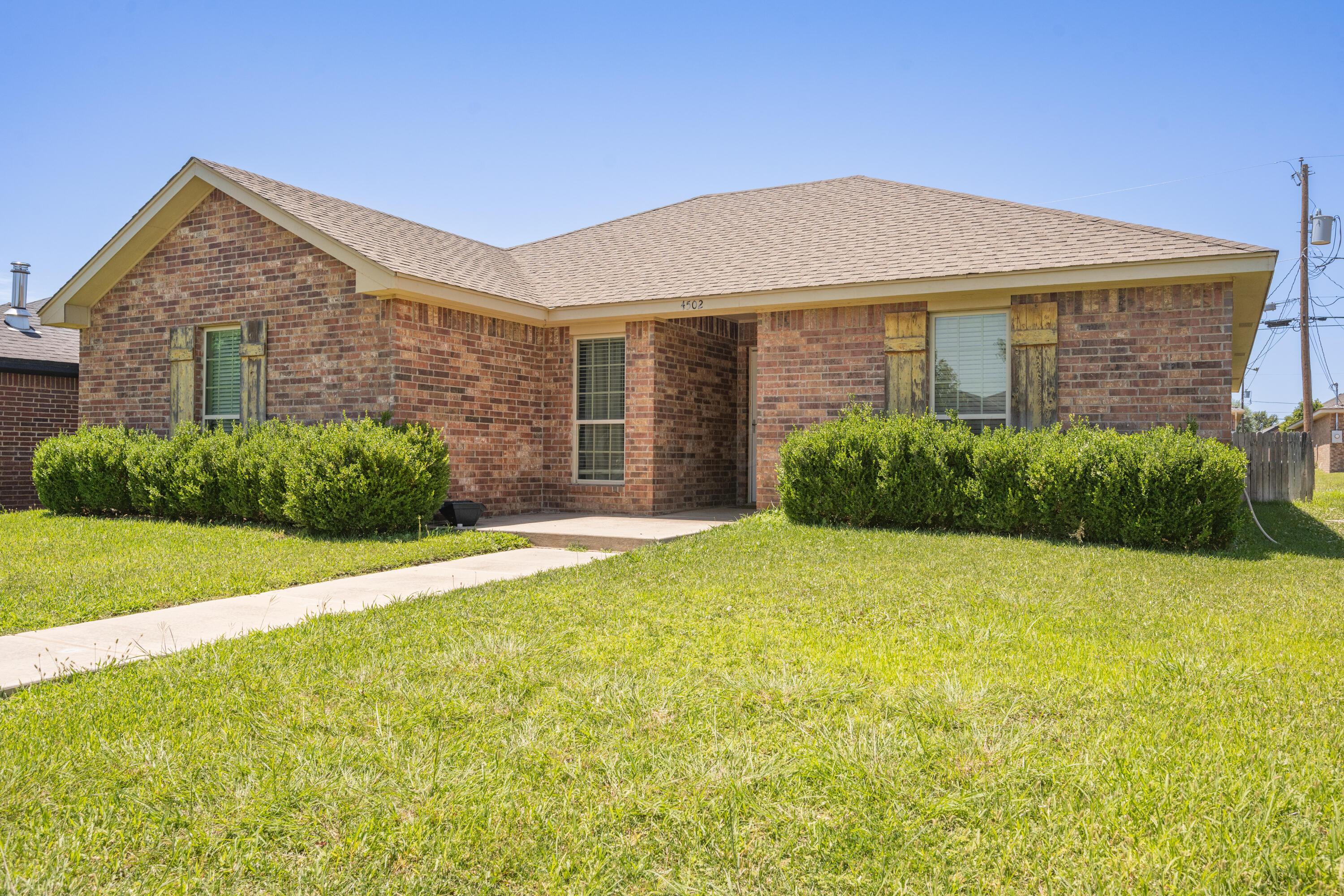4502 Pine Street Amarillo, TX 79118 - Photo 2 of 20 a front view of a house with a yard