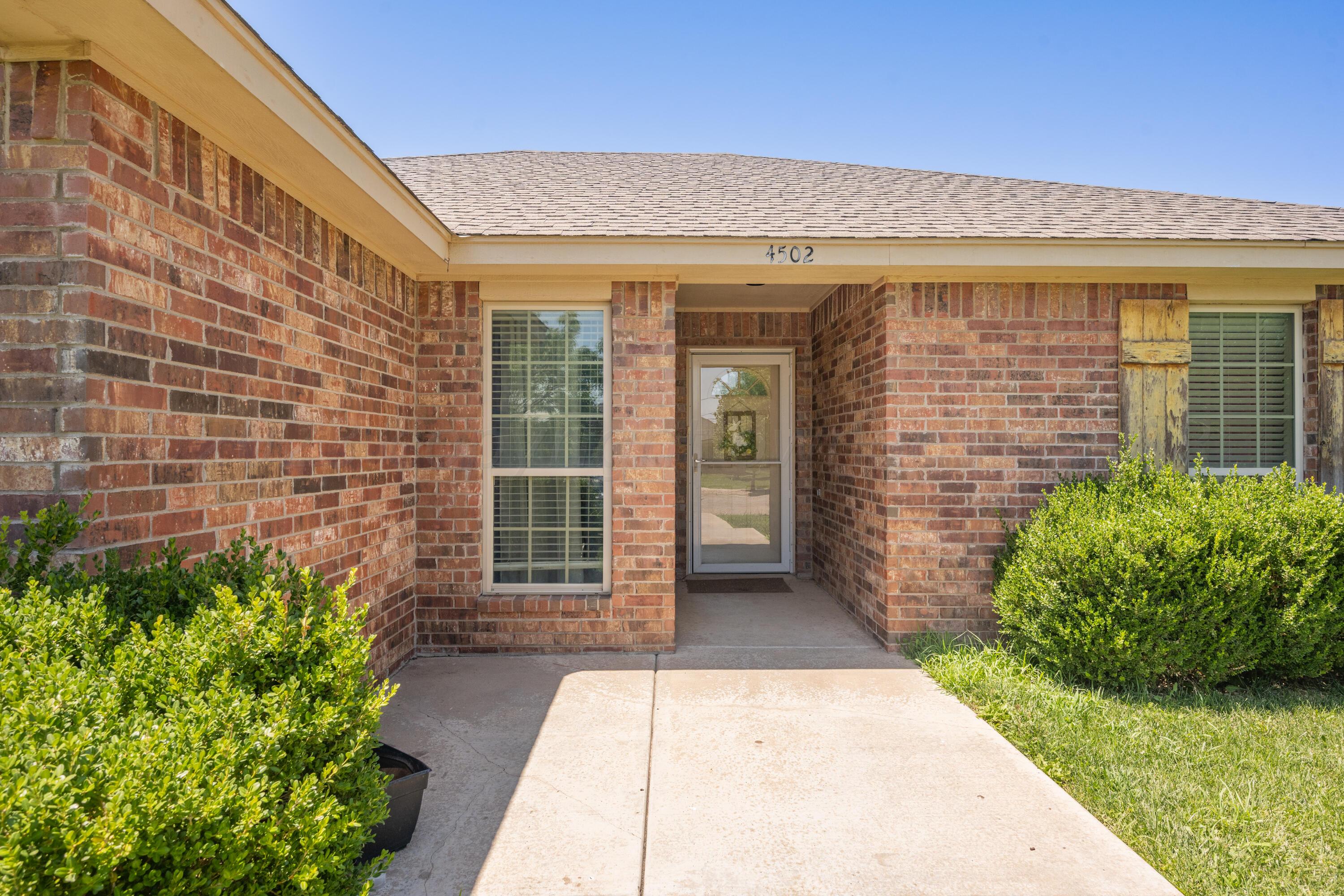 4502 Pine Street Amarillo, TX 79118 - Photo 3 of 20 a view of a brick house with potted plants