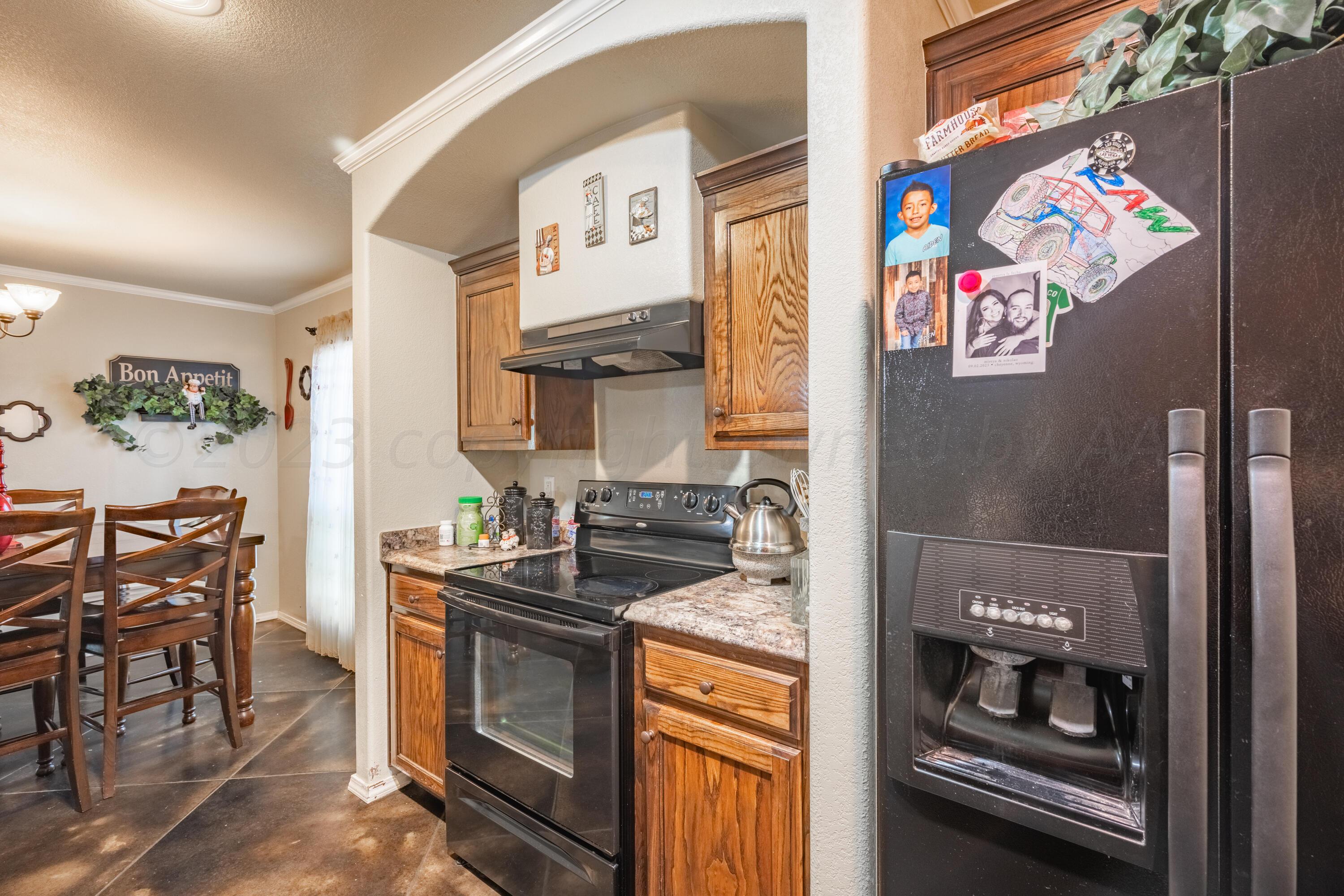 4502 Pine Street Amarillo, TX 79118 - Photo 9 of 20 a kitchen with stainless steel appliances granite countertop a stove and a refrigerator