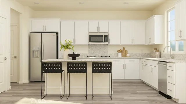 a kitchen with stainless steel appliances granite countertop a stove a sink and a refrigerator