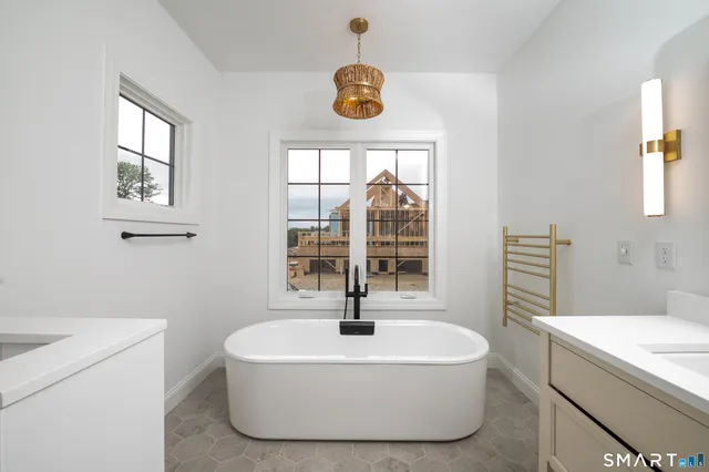 a white bath tub sitting in a bathroom next to a window
