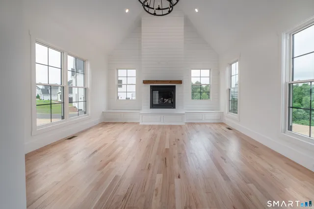 an empty room with windows and fireplace