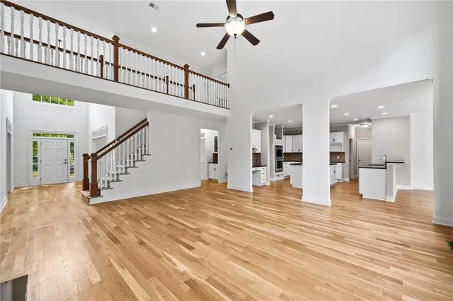 an empty room with windows and ceiling fan