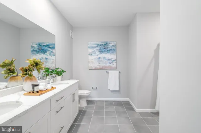 a bathroom with a sink a toilet and a mirror