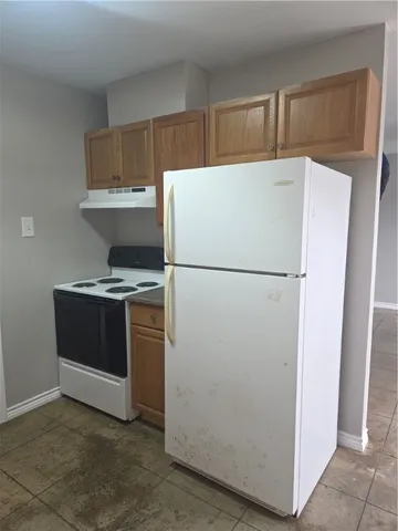 a white refrigerator freezer and a stove sitting inside of a kitchen