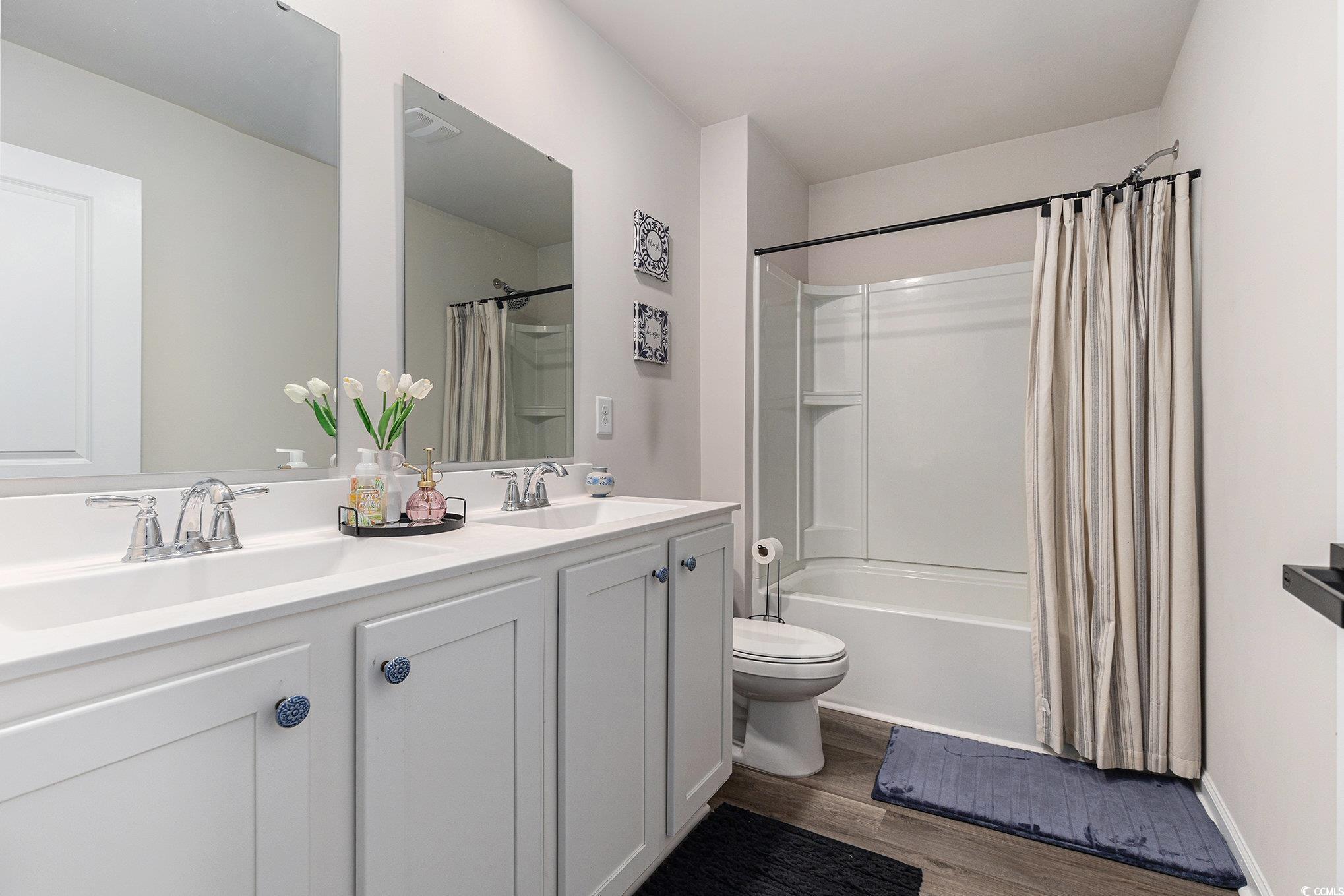 651 Choctaw Drive Conway, SC 29526 - Photo 17 of 37 Full bath with shower / bath combo with shower curtain, double vanity, and dark wood-style floors