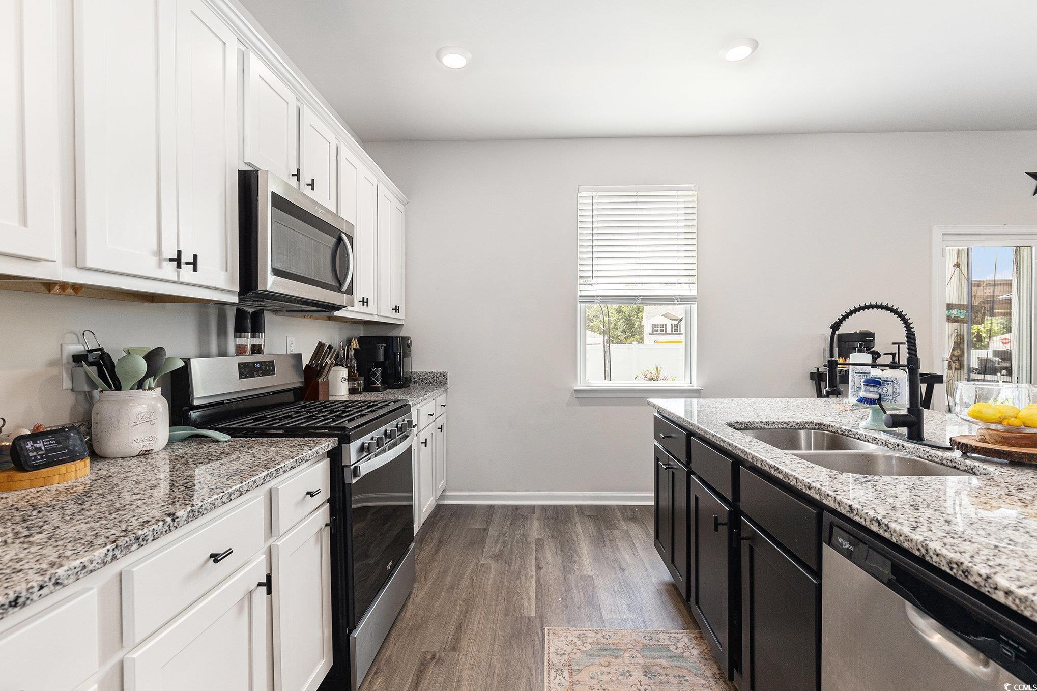 651 Choctaw Drive Conway, SC 29526 - Photo 4 of 37 Kitchen with appliances with stainless steel finishes, light stone counters, white cabinets, dark wood-style floors, and dark cabinets