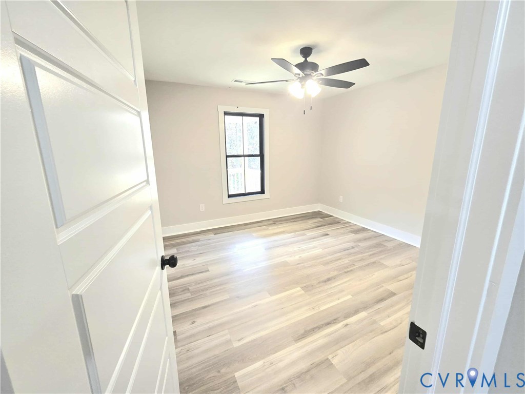 1775 Bumpass Road Bumpass, VA 23024 - Photo 27 of 42 a view of empty room with wooden floor and fan