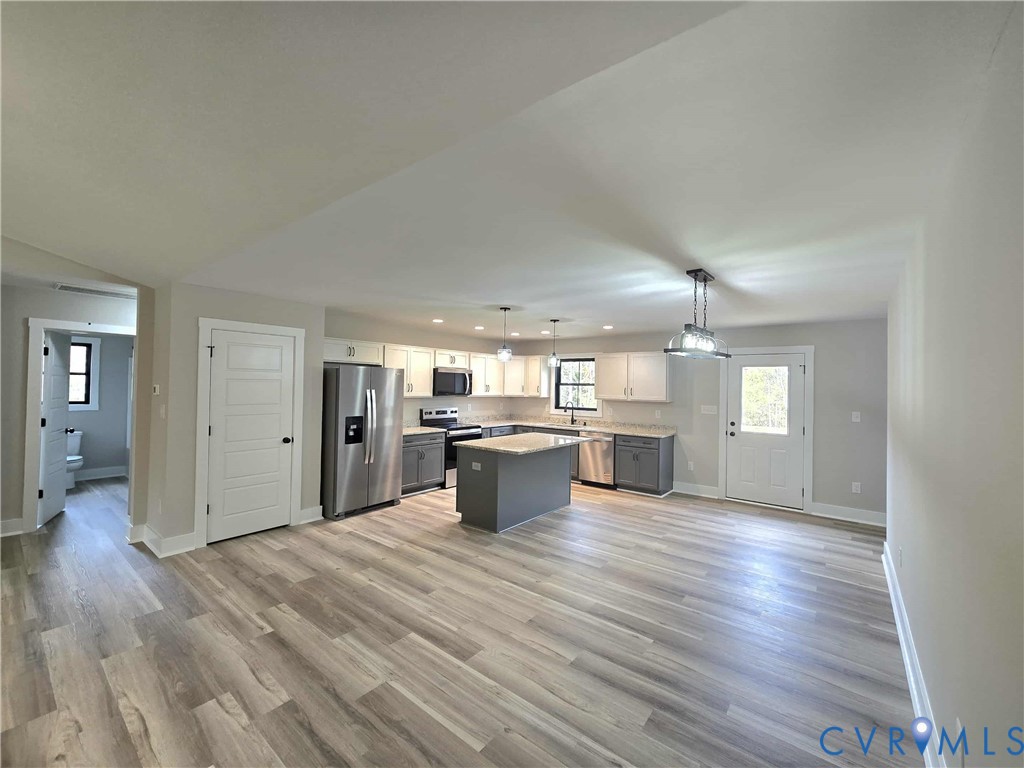 1775 Bumpass Road Bumpass, VA 23024 - Photo 35 of 42 an open kitchen with a sink and wooden floor