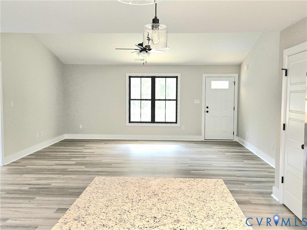 1775 Bumpass Road Bumpass, VA 23024 - Photo 9 of 42 wooden floor in an empty room with a window
