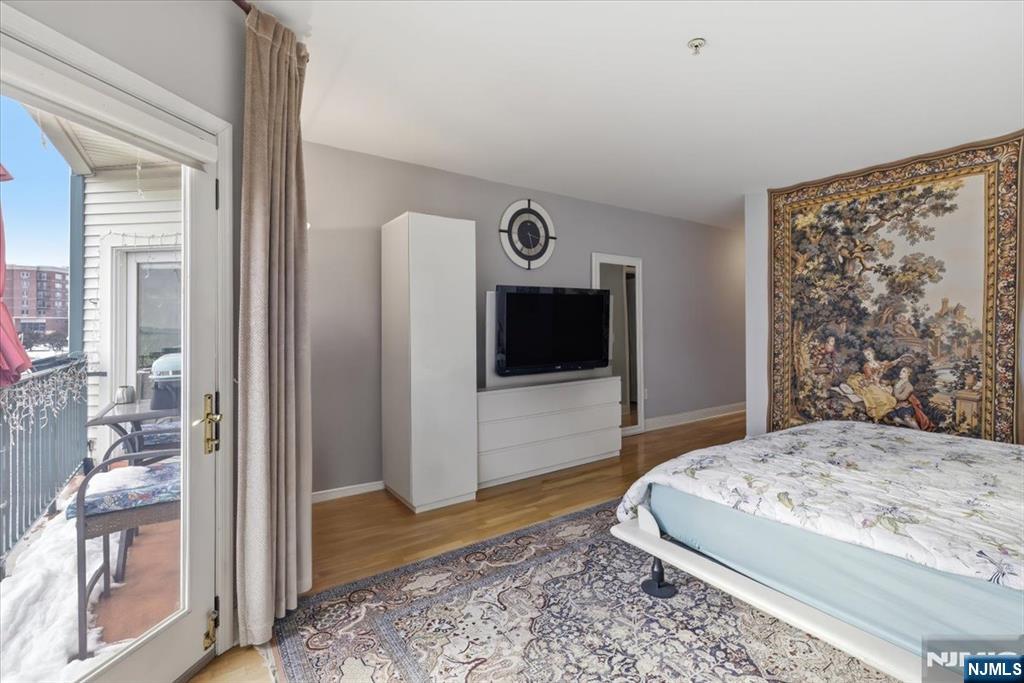214 The Promenade, Unit 214 Edgewater, NJ 07020 - Photo 20 of 36 a bedroom with a bed and a television