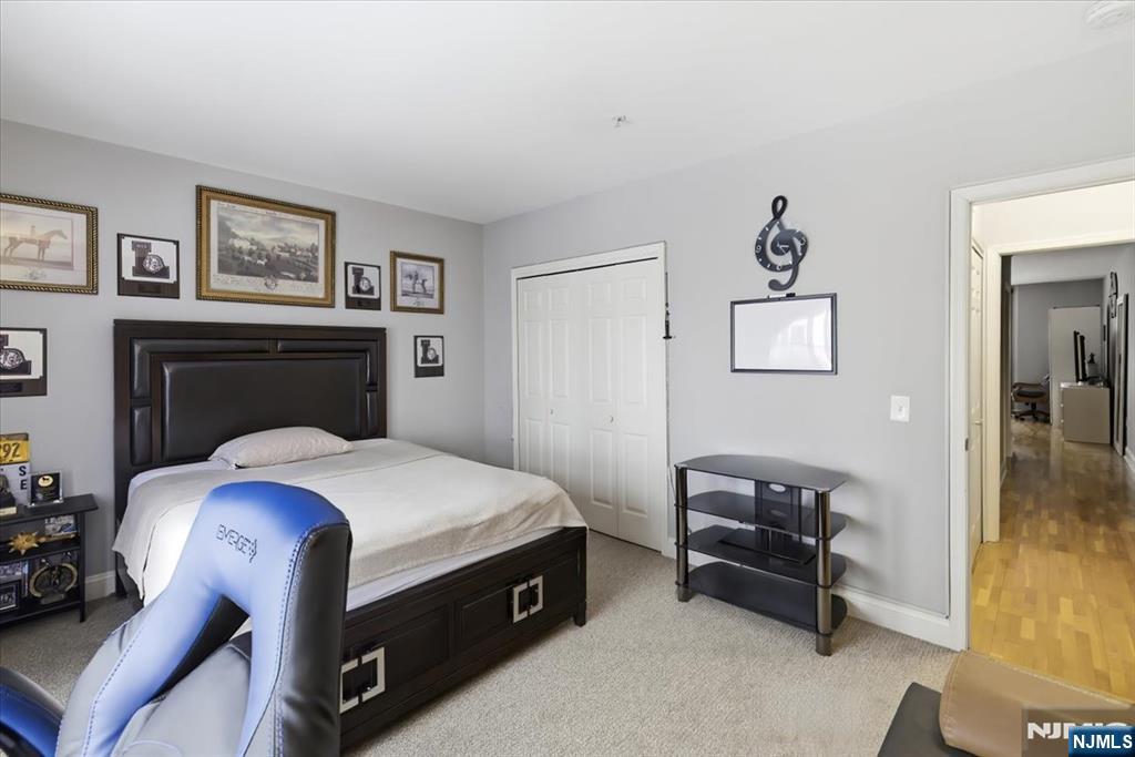 214 The Promenade, Unit 214 Edgewater, NJ 07020 - Photo 24 of 36 a bedroom with a bed and a chandelier