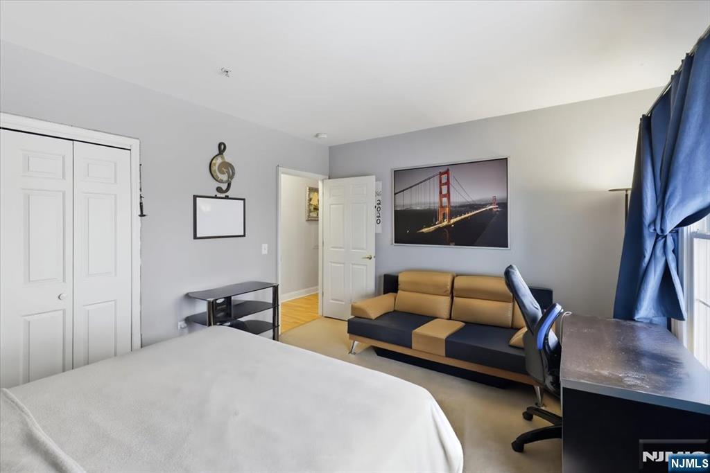 214 The Promenade, Unit 214 Edgewater, NJ 07020 - Photo 25 of 36 a bedroom with a bed and a couch