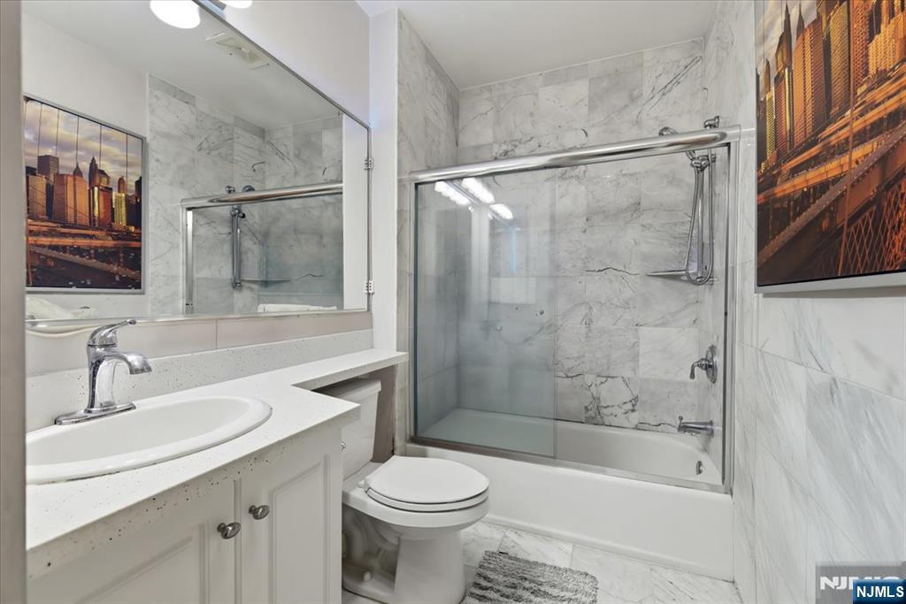 214 The Promenade, Unit 214 Edgewater, NJ 07020 - Photo 28 of 36 a bathroom with a sink toilet and shower