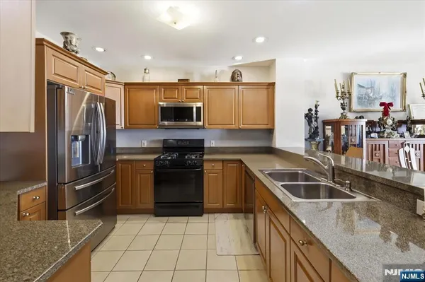 a kitchen with granite countertop a refrigerator and a stove top oven