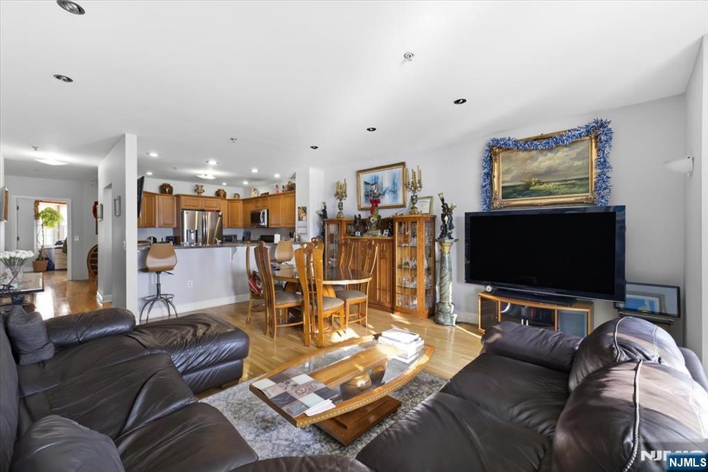 214 The Promenade, Unit 214 Edgewater, NJ 07020 - Photo 5 of 36 a living room with furniture and a flat screen tv