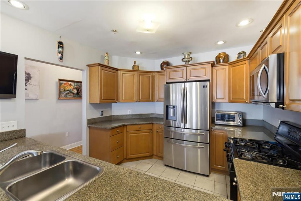 214 The Promenade, Unit 214 Edgewater, NJ 07020 - Photo 9 of 36 a kitchen with stainless steel appliances granite countertop a refrigerator stove and sink
