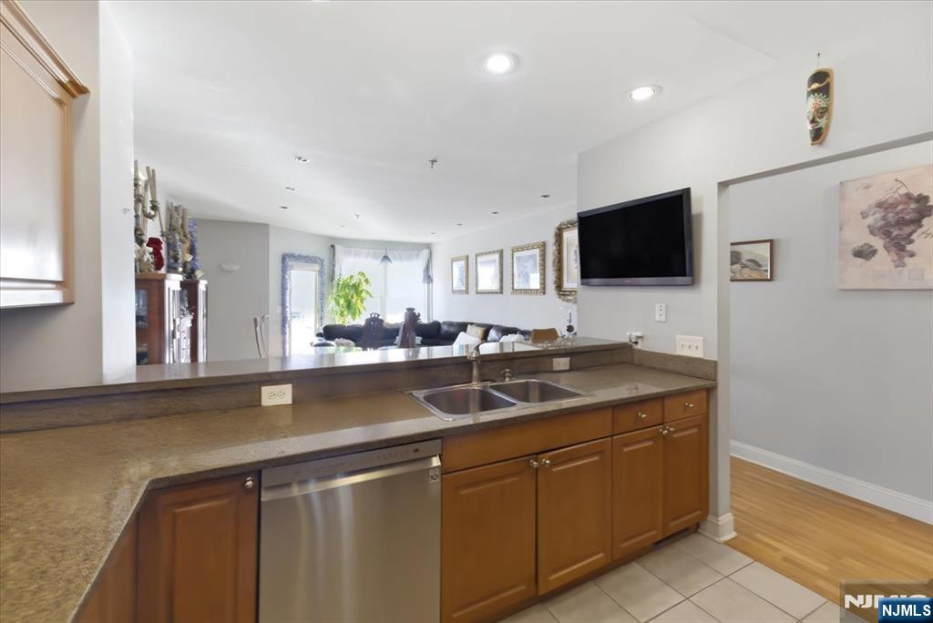 214 The Promenade, Unit 214 Edgewater, NJ 07020 - Photo 10 of 36 a kitchen with a sink and a wooden floor
