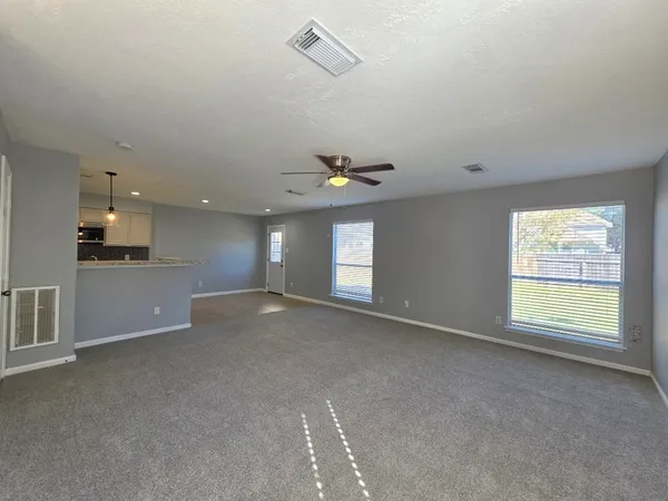 a view of a livingroom with a ceiling fan and window
