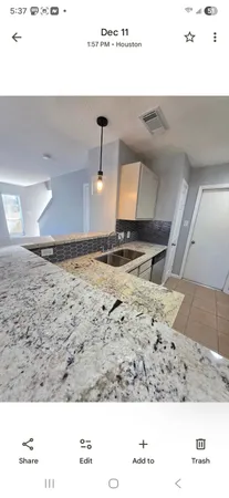 a view of a big room with windows and chandelier fan