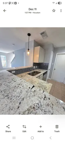 a view of a big room with windows and chandelier fan