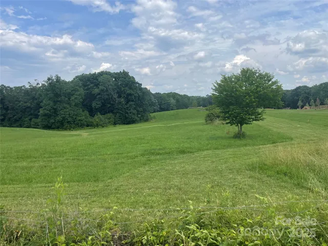 a view of a green field with wooden fence