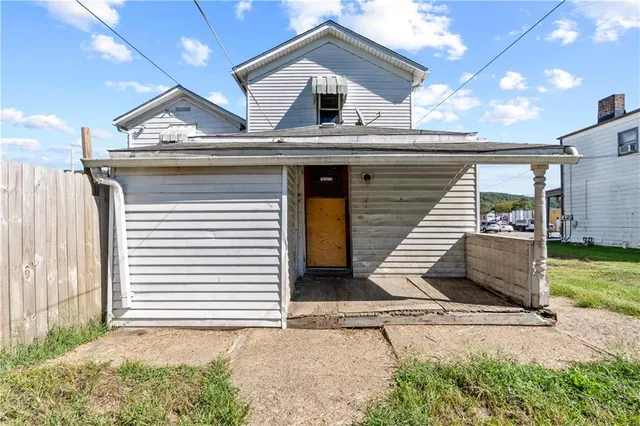 a view of a house with backyard and trees