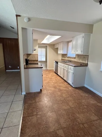 a large kitchen with stainless steel appliances granite countertop a stove a sink and a refrigerator