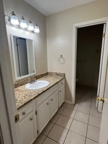 a bathroom with a granite countertop sink a mirror and a vanity