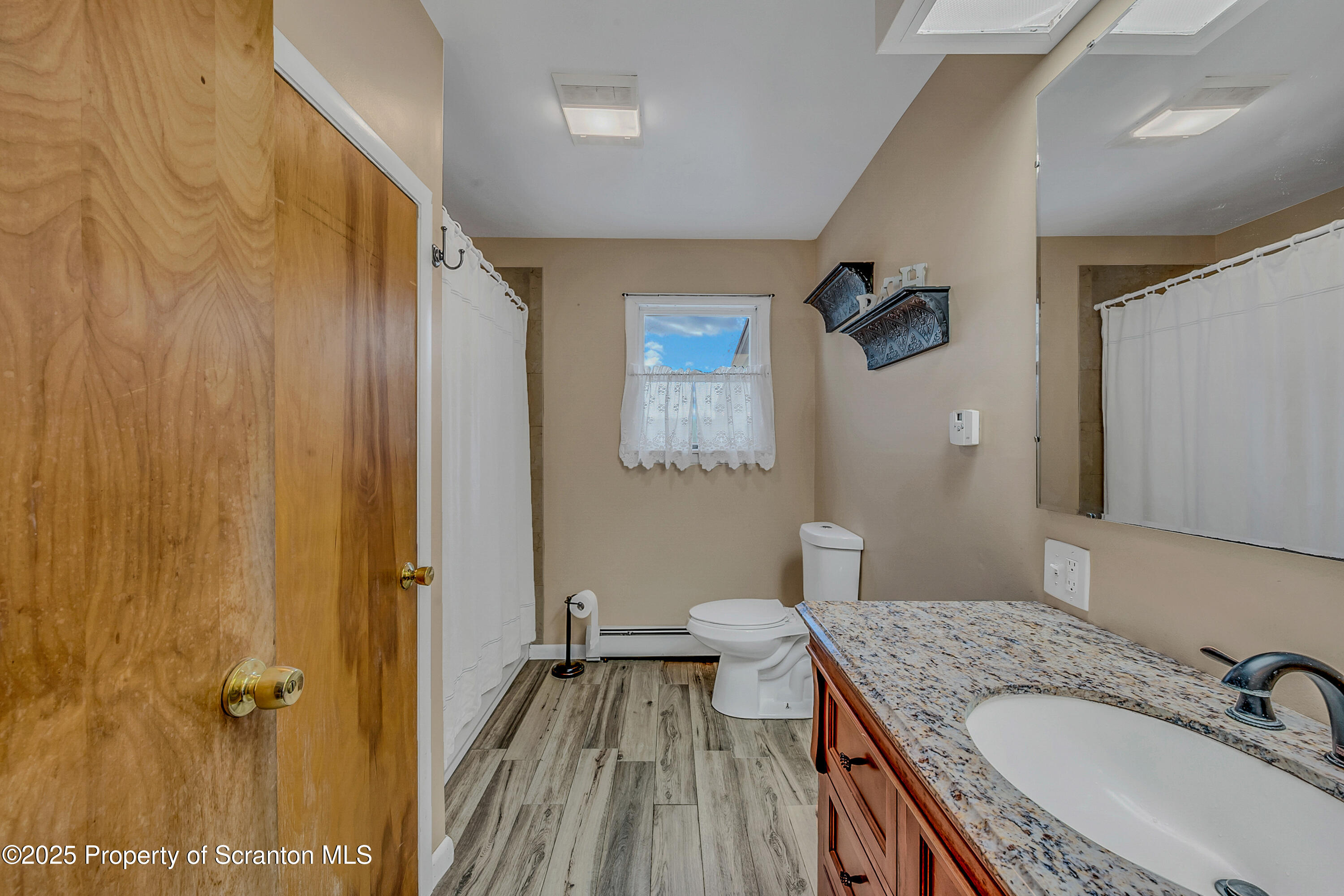 1001 Griggs Street Clarks Summit, PA 18411 - Photo 28 of 55 a bathroom with a granite countertop sink a mirror and a shower