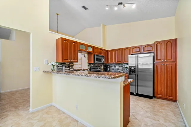 a kitchen with stainless steel appliances a refrigerator and a stove top oven