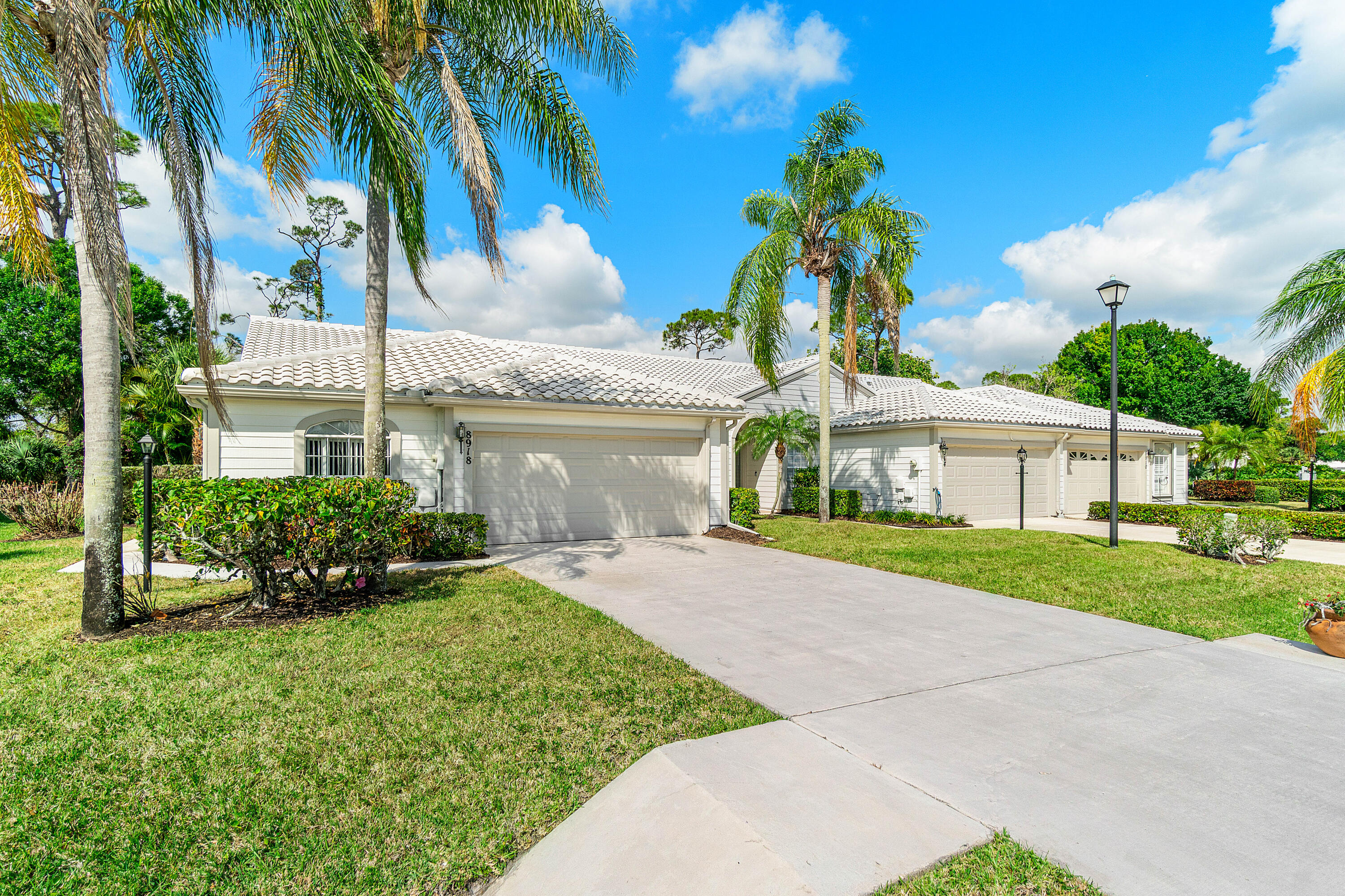 8918 Southeast Riverfront Terrace Jupiter, FL 33469 - Photo 2 of 43 a front view of a house with a yard and garage