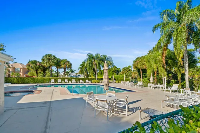 a view of a swimming pool with lawn chairs under an umbrella
