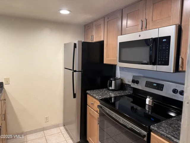 a kitchen with stainless steel appliances granite countertop a refrigerator and a stove top oven