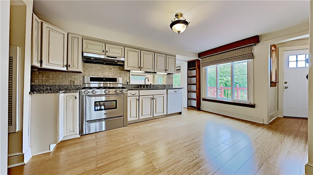 8150 Peebles Road Pittsburgh, PA 15237 - Photo 7 of 25 a kitchen with stainless steel appliances granite countertop a refrigerator a stove top oven a sink and dishwasher with wooden floor