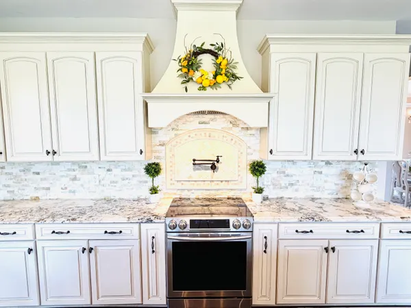 a front view of a house with garden and trees